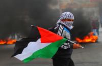 فلسطيني يرفع علم فلسطين