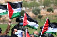 فلسطينيوم يرفعون أعلام فلسطينية