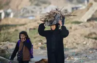 امرأة فلسطينية تحمل حطباً لإشعال النار