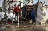 فلسطيني مصاب بحالة بتر يطرد المياه من أمام خيمته
