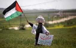 فلسطينية ترفع علم فلسطين على الشرييط الحدودي