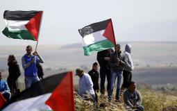 فلسطينيون يرفعون علم فلسطين