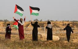 سيدات يرفعن علم فلسطين على الشريط الحدودي