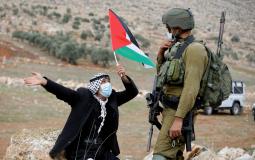 فلسطيني يرفع علم فلسطين