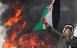 راجل مسن يحمل علم فلسطين