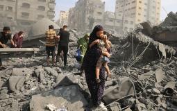 سيدة تخرح وطفلها من القصف على غزة