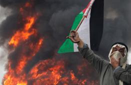 راجل مسن يحمل علم فلسطين