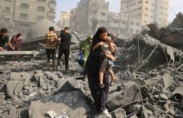 سيدة تخرح وطفلها من القصف على غزة