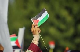 علم فلسطين في يد سيدة فلسطينية