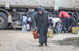 سيدة فلسطينية تحمل الماء في النزوح
