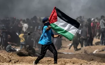 طفل فلسطيني يرفع علم فلسطين