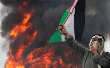 راجل مسن يحمل علم فلسطين