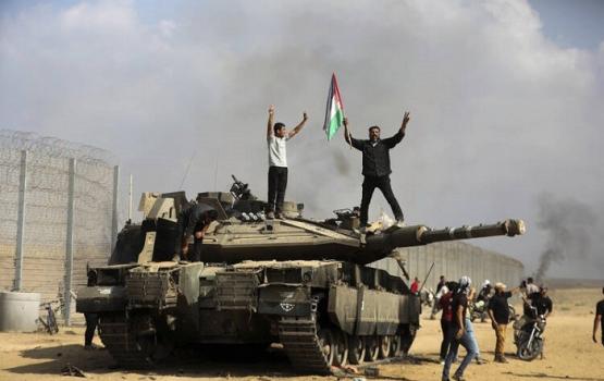 فلسطيين من غزة يعتلى دبابة إسراءيلية على حدود عزة في السابع من أكتوبر