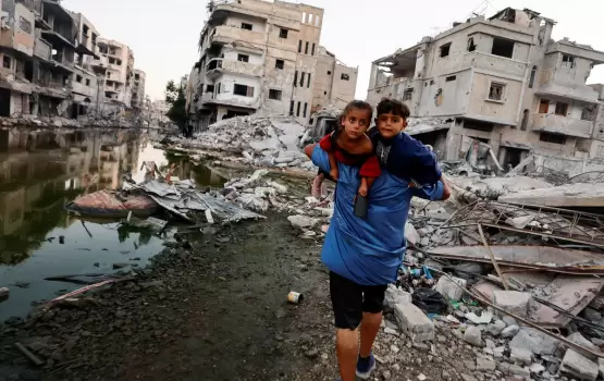 فلسطيني يحمل اطفاله على ظهره اثناء إخلاء منزله
