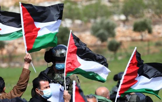 فلسطينيوم يرفعون أعلام فلسطينية