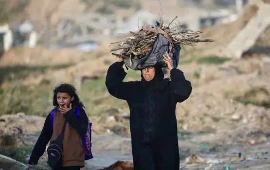 امرأة فلسطينية تحمل حطباً لإشعال النار