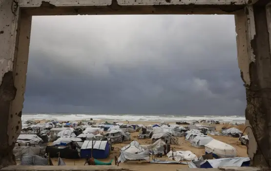 مشهد الخيام على شاطئ غزة من بيت مدمر