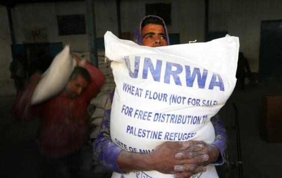 لاجئ فلسطيني يتلقى مساعدات اغاثية من الاونروا