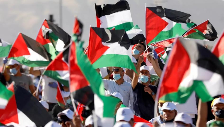 متظاهرون يرفعون أعلام فلسطين