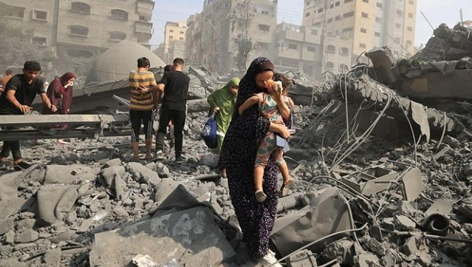 سيدة تخرح وطفلها من القصف على غزة