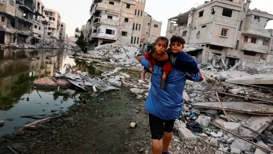 فلسطيني يحمل اطفاله على ظهره اثناء إخلاء منزله