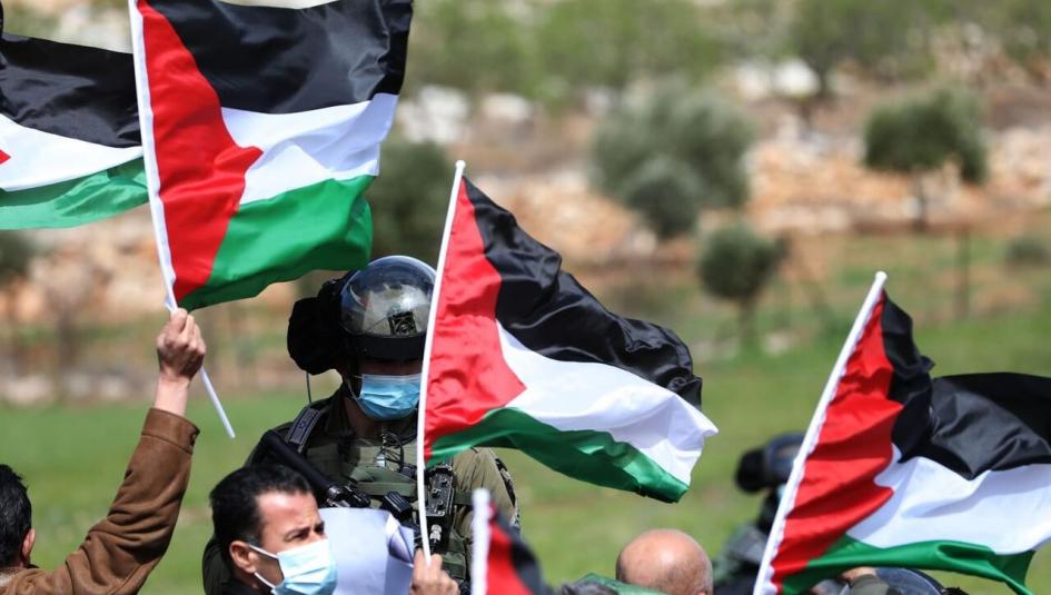 فلسطينيوم يرفعون أعلام فلسطينية