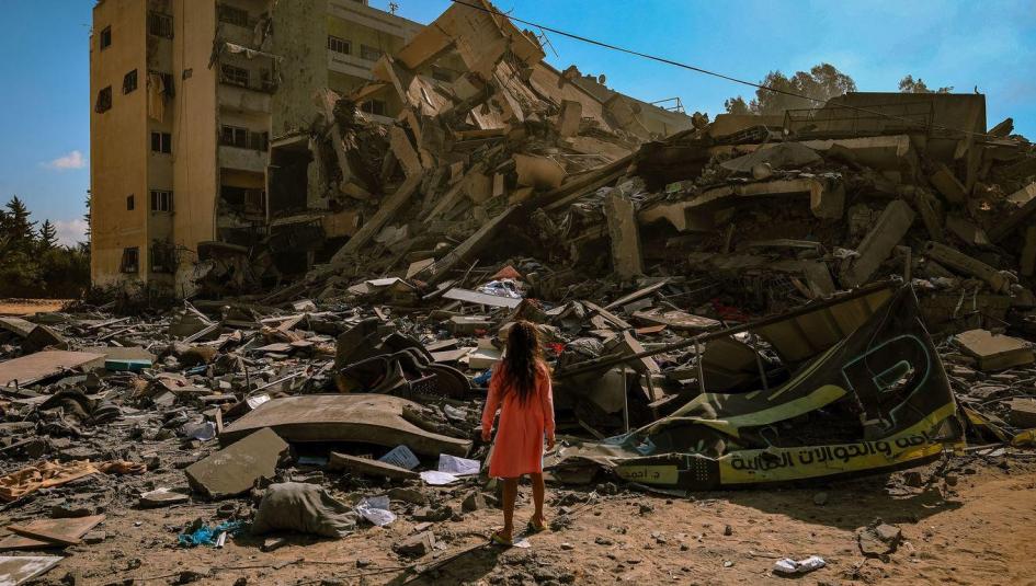 طفلة تنظر إلى انقاض منزلها المدمر